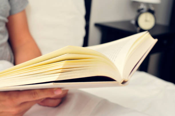 istock young man reading a book in bed 1084109276
