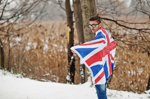 Stylish indian man in suit with Great Britain flag posed at winter day outdoor.
