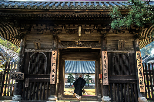 The Japanese Abbot enters to Tosho-ji Buddhist temple through the Torii gate in Okayama Prefecture, Japan.