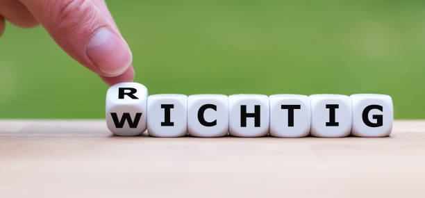 hand is turning a dice and changes the german word "richtig" to "wichtig" as symbol for a really important message - wichtig imagens e fotografias de stock
