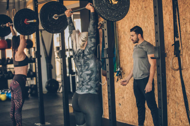 istock Women training with personal trainer in gym 1084117316