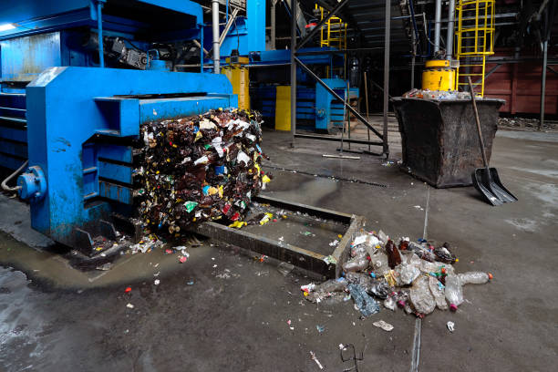 istock Modern waste sorting and recycling plant, hydraulic press makes wired bale from pressed PET bottles for processing and reuse of plastic. Concept of environment defence materials reuse 1084122836