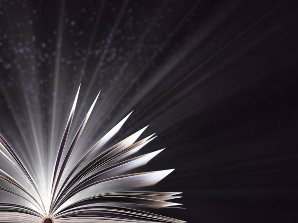 istock Part of an open magic book, bewitched book glows in the darkness, magic light. Education. Dreamy image of a fairytale 1084125146