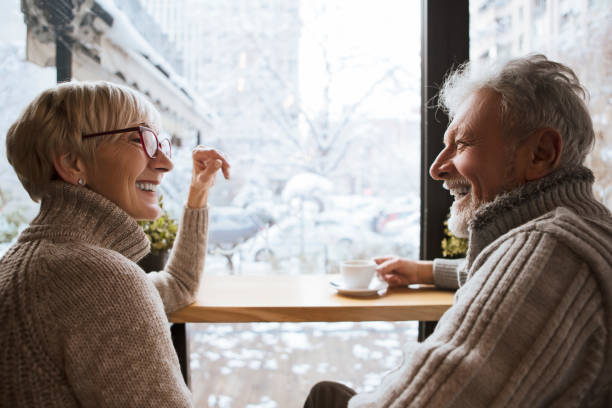 lachende senioren gelast kopje koffie - cafe snow stockfoto's en -beelden