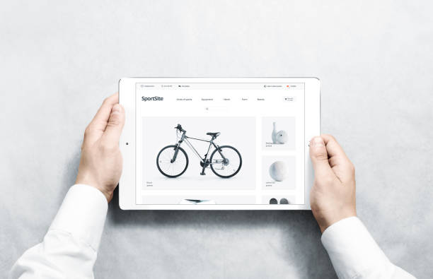 istock Hands holding tablet with sport webstore mock up on screen 1084132256