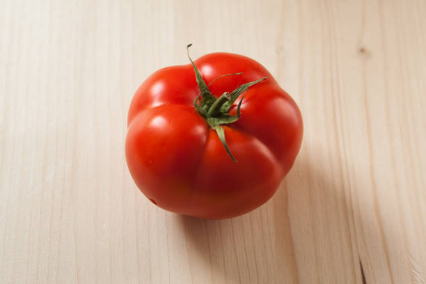 Close-up of red ripe tomato is  on wooden background Top view