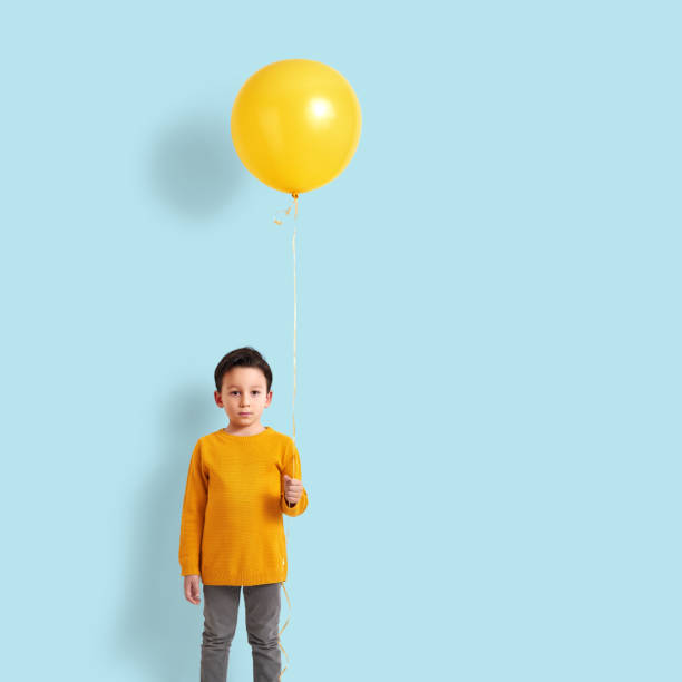 Cute child holding a yellow balloon