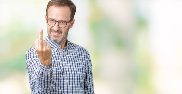 istock Handsome middle age elegant senior man wearing glasses over isolated background Showing middle finger, impolite and rude fuck off expression 1084161508