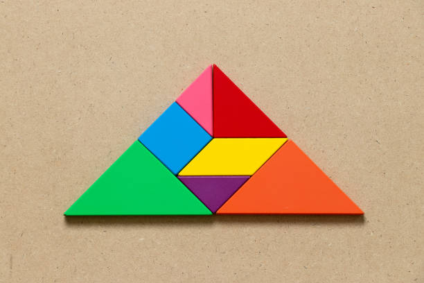 istock Color tangram puzzle in triangle shape on wood background 1084165678