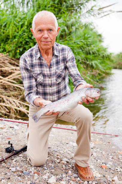 istock Mature fisherman examining catch 1084165804