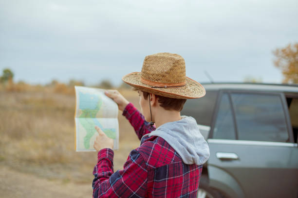 istock young man in hat with road map and binoculars searching the correct road  f 1084165898