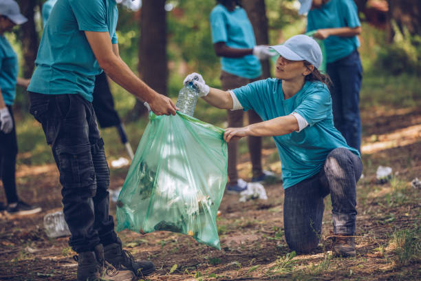 istock Volunteers with garbage bags in public park 1084167978