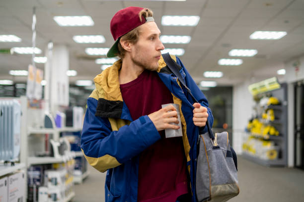 shoplifter in the electronic store supermarket stealing new gadget f stock photo