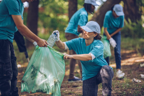istock Volunteers with garbage bags in public park 1084169328