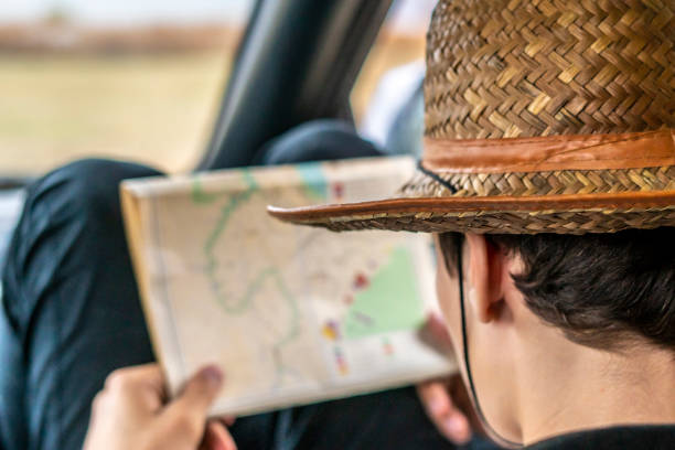 istock young man searching the way using a map sitting in the car f 1084170684