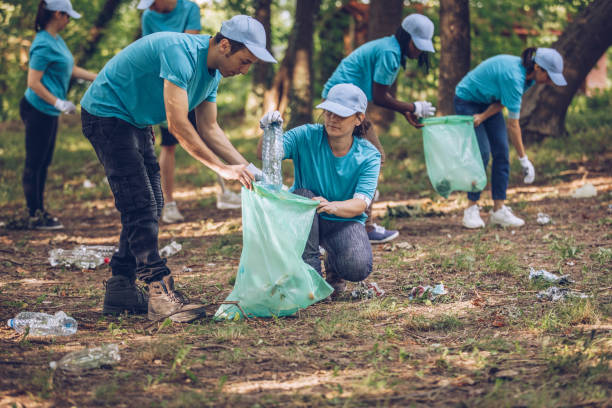 istock Volunteers with garbage bags in public park 1084170814