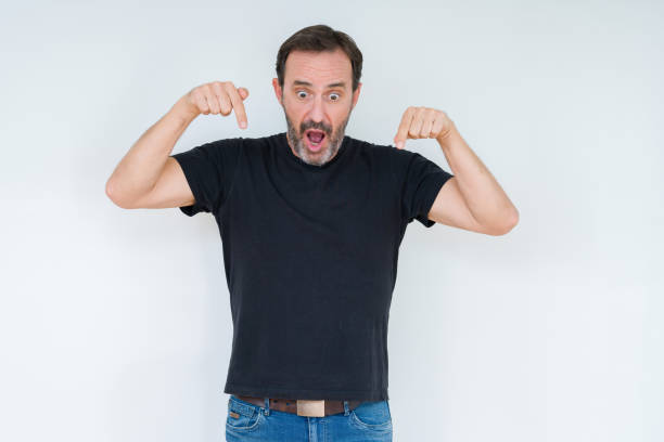 istock Senior man over isolated background Pointing down with fingers showing advertisement, surprised face and open mouth 1084171914