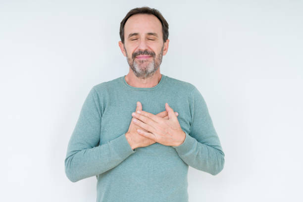 istock Senior man over isolated background smiling with hands on chest with closed eyes and grateful gesture on face. Health concept. 1084173722