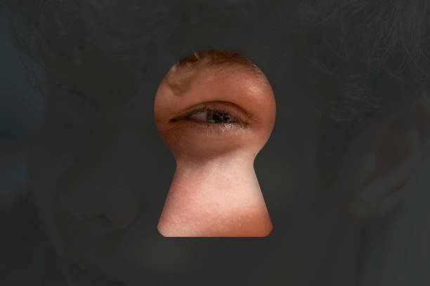 istock person eye spying in the keyhole g 1084174650