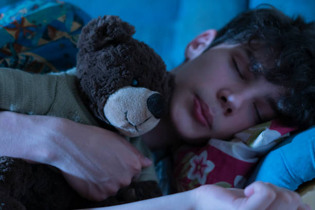 istock young guy in bed sleeping and hug teddy bear  f 1084174652