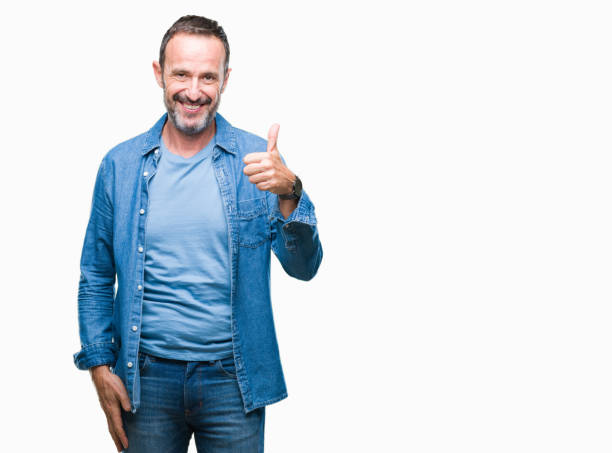 istock Middle age hoary senior man over isolated background doing happy thumbs up gesture with hand. Approving expression looking at the camera with showing success. 1084177010