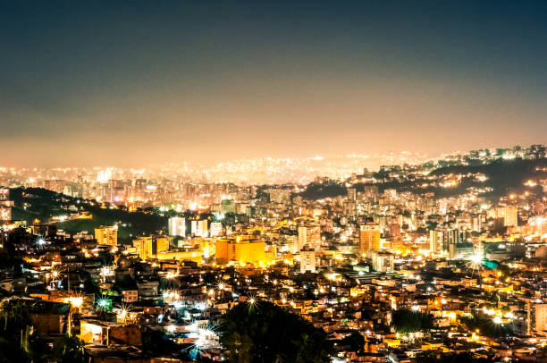 night view cityscape of caracas during summer clear sky with view of hills with the slums, so called barrios stock photo