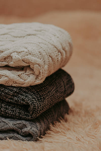 istock knitted sweaters on a soft peach carpet close-up 1084177894