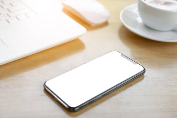 istock Mock up Blank screen of smartphone with a coffee cup on wooden table blurred background 1084178078