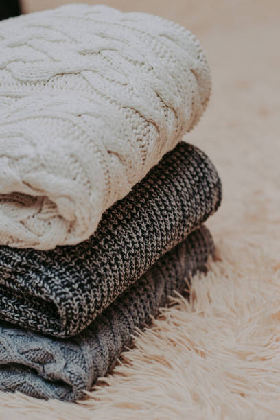 istock knitted sweaters on a soft peach carpet close-up 1084178308