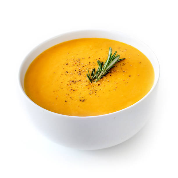 Bowl of pumpkin and carrot cream soup isolated on white background Bowl of pumpkin and carrot cream soup isolated on white background carrot isolated vegetable nobody stock pictures, royalty-free photos & images