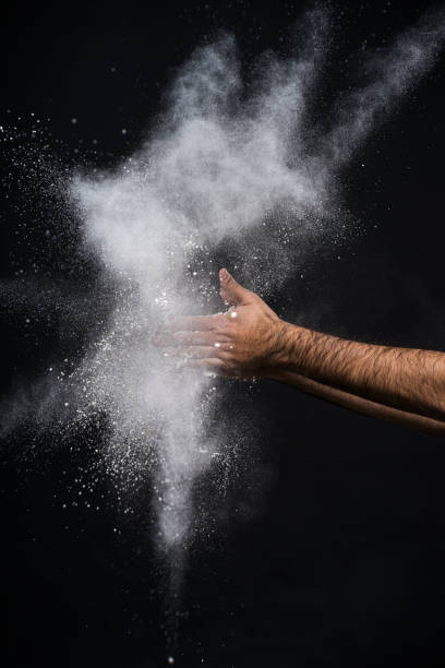 Studio shot of a man's hand with flour against black background
