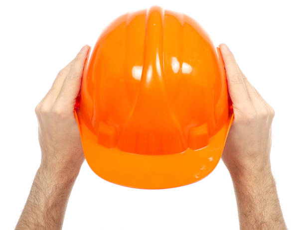 istock Orange male helmet in hand 1084192834