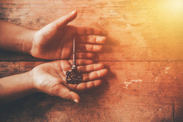 human hand holding a key human hand holding a key old key stock pictures, royalty-free photos & images