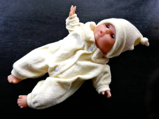 istock Baby doll pale yellow clothes isolated on black background 1084217580