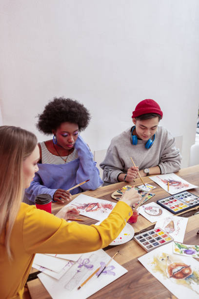 istock Three fashionable art students attending drawing class 1084218346