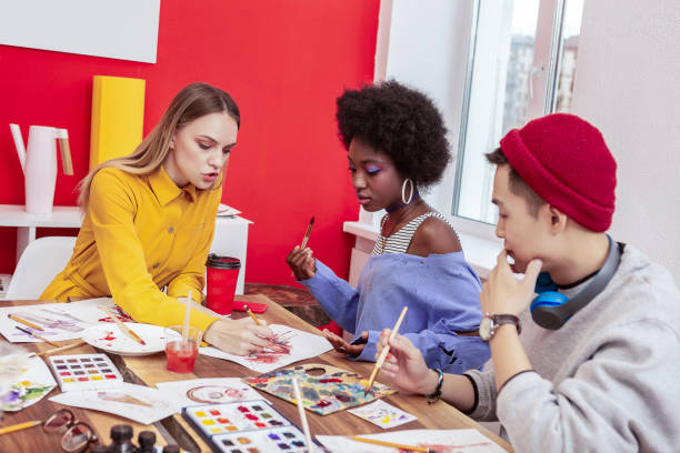 istock Blonde-haired artist giving master class to talented students 1084218358