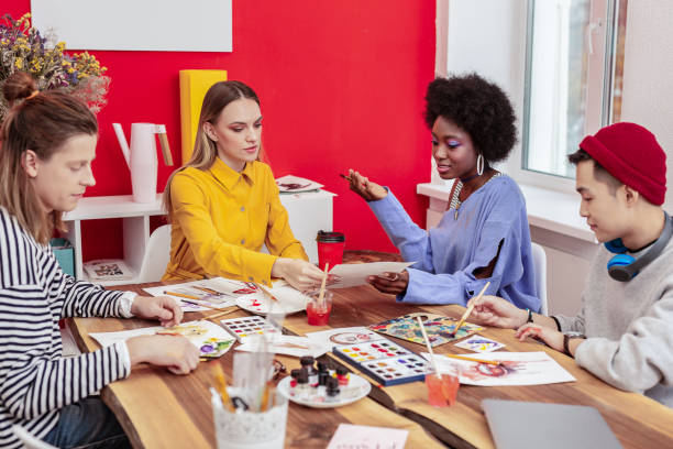 istock Four art students drinking coffee and drawing on their weekend 1084218382