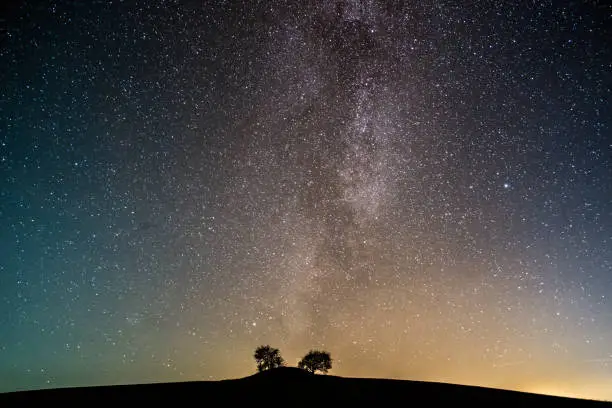 Colour photograph of the Milkyway over ancient burial mound on the island of Møn in Denmark. Horizontal format with some copy space.