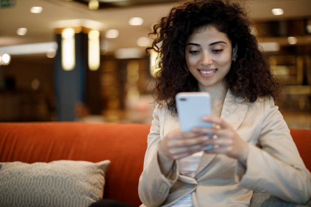 istock Businesswoman using mobile phone in hotel lobby 1084224784