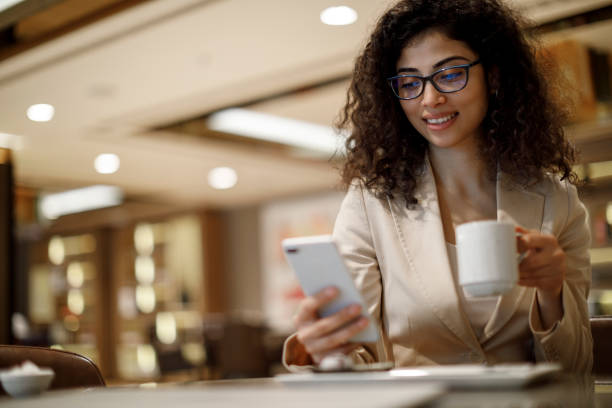 istock Businesswoman using mobile phone at a cafe 1084225172