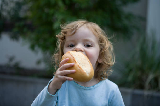 istock Cute Girl Eating Bread 1084225436