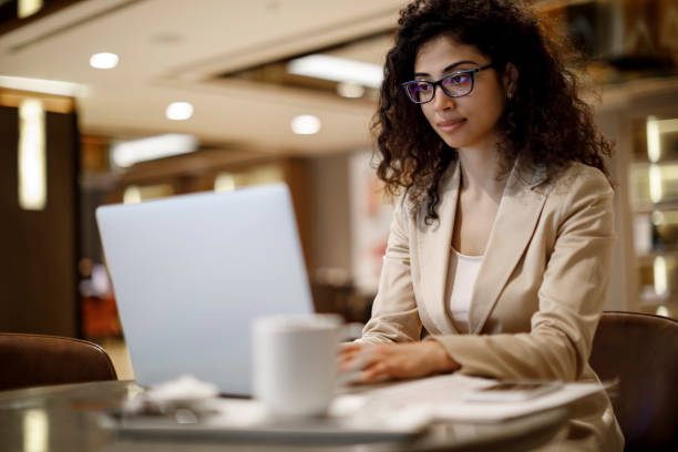 istock Businesswoman working on laptop at a cafe 1084225844