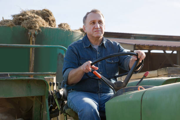 istock Senior aged man working on small farm tractor 1084228140