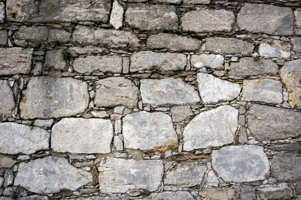 istock Old stone wall of irregular stones in old Europe 1084231380