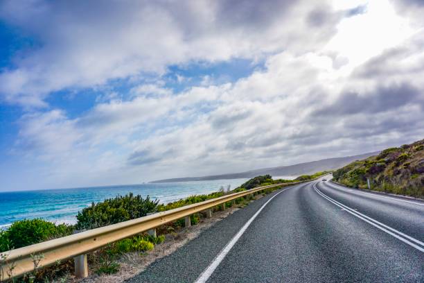 istock Road next to an wonderful ocean, beach and mountains 1084232970