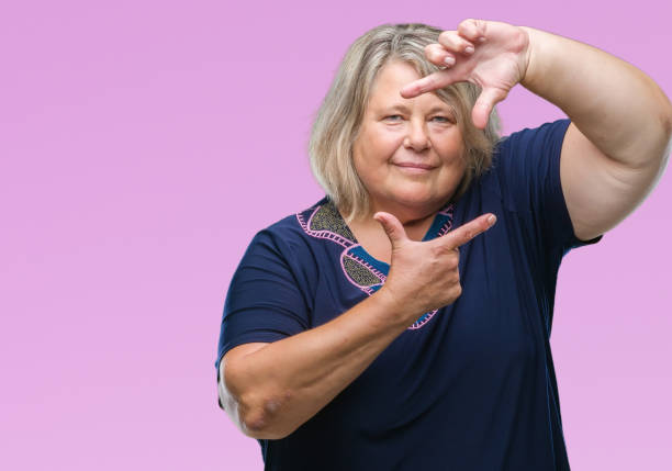istock Senior plus size caucasian woman over isolated background smiling making frame with hands and fingers with happy face. Creativity and photography concept. 1084238810