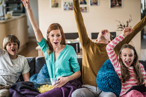 istock Family celebrating on the couch while watching TV 1084239752