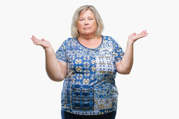 istock Senior plus size caucasian woman over isolated background clueless and confused expression with arms and hands raised. Doubt concept. 1084239998