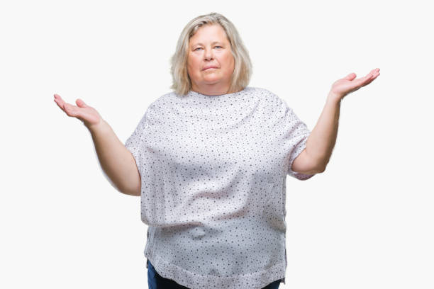 istock Senior plus size caucasian woman over isolated background clueless and confused expression with arms and hands raised. Doubt concept. 1084240186