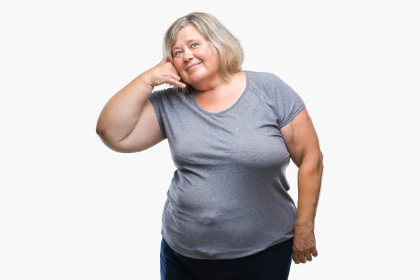istock Senior plus size caucasian woman over isolated background smiling doing phone gesture with hand and fingers like talking on the telephone. Communicating concepts. 1084242016